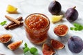 Fresh figs, with a dish of homemade fig jam or preserves marmalade kitchen marble table background. Royalty Free Stock Photo