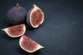 Fresh figs. Food photography. Creative scheme of whole and sliced figs on a dark background. Copy space. Royalty Free Stock Photo