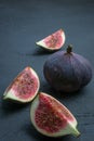 Fresh figs. Food photography. Creative scheme of whole and sliced figs on a dark background. Copy space. Royalty Free Stock Photo