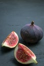 Fresh figs. Food photography. Creative scheme of whole and sliced figs on a dark background. Copy space. Royalty Free Stock Photo