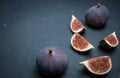 Fresh figs. Food photography. Creative scheme of whole and sliced figs on a dark background. Copy space. Royalty Free Stock Photo