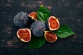 Fresh figs with leaves on a black wooden table. Free space for text. Royalty Free Stock Photo