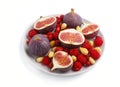 Fresh figs, strawberries and raspberries on white ceramic plate isolated on white background. side view Royalty Free Stock Photo