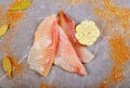 Raw fresh fillet of tilapia with seasonings and garlic