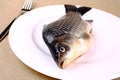 Fresh fish carp on a white plate with fork Royalty Free Stock Photo