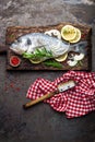 Fresh fish dorado with ingredients for cooking on wooden board. Raw sea bream or dorada fish on dark vintage metal background. Die Royalty Free Stock Photo