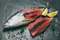 Fresh fish fillet sliced for steak or salad with herbs spices rosemary and lemon - Raw fish seafood on black plate background , Royalty Free Stock Photo