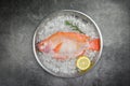 Fresh fish on ice with herbs spices rosemary and lemon / Raw fish red tilapia on black background Royalty Free Stock Photo