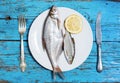 Fresh fish on the plate, table setting, wooden background Royalty Free Stock Photo