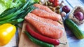 Fresh Fish Raw Salmon Two steaks with ingredients vegetables and spices tomatoes lemon and olives cucumber green salat onion g Royalty Free Stock Photo