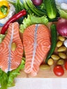 Fresh Fish Raw Salmon Two steaks with ingredients vegetables and spices tomatoes lemon and olives cucumber green salat onion g Royalty Free Stock Photo