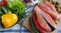 Fresh Fish Raw Salmon Two steaks with ingredients vegetables and spices tomatoes lemon and olives cucumber green salat onion g Royalty Free Stock Photo