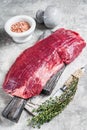 Fresh Flank or flap raw beef steak on wooden board with herbs. Gray background. Top view