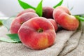 Fresh Flat Peaches, Chinese Saturn Donut Peaches with Leaves on Wooden Bright Background Royalty Free Stock Photo