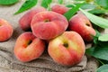 Fresh Flat Peaches, Chinese Saturn Donut Peaches with Leaves on Wooden Bright Background Royalty Free Stock Photo