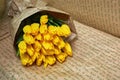 Fresh flower composition, bouquet yellow tulips in wrapping paper on craft paper background. Valentine, Women`s, 8 march