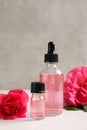 Fresh flowers and bottles of rose essential oil on table Royalty Free Stock Photo