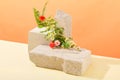 Fresh flowers and green leaves arranged on varied-sized stone podiums against a pastel background create a creative, artistic