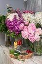 Fresh flowers, leaves, and tools to create a bouquet on a table, florist's workplace. Royalty Free Stock Photo