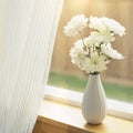 Fresh flowers in vase on windowsill with sheer fabric curtains window coverings. Simple, natural, home interior decor.