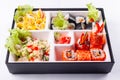 Fresh food portion in japanese bento box with salad, main course. Sushi roll with vegetables. Vegetarian dish.