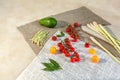 Fresh food on a textured background with bay leaf ingredients cherry tomatoes lemongrass avocado wild leek