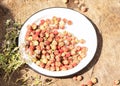 Fresh forest strawberries on a white metal plate. Wooden table in the courtyard of the house. Nearby lies thyme grass Royalty Free Stock Photo