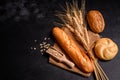 Fresh fragrant bread with grains and cones of wheat against a dark background Royalty Free Stock Photo