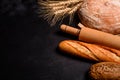 Fresh fragrant bread with grains and cones of wheat against a dark background Royalty Free Stock Photo