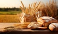 Fresh fragrant bread laid on a rustic wooden table with a wheat field in the background.