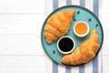 Fresh french croissants with chocolate on blue plate, blueberry jam, honey, napkin coffee grains on white background Continental Royalty Free Stock Photo