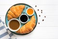 Fresh french croissants with chocolate on plate, blueberry jam, honey, napkin, white cup of espresso coffee, coffee Royalty Free Stock Photo