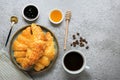 Fresh french croissants with chocolate on plate, blueberry jam, honey, napkin, white cup of espresso coffee, coffee grains on gray Royalty Free Stock Photo