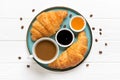 Fresh french croissants with chocolate on plate, blueberry jam, honey, napkin, white cup of espresso coffee, coffee grains on Royalty Free Stock Photo