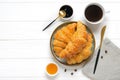 Fresh french croissants with chocolate on plate, blueberry jam, honey, napkin, white cup of espresso coffee, coffee grains on Royalty Free Stock Photo