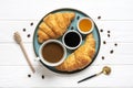 Fresh french croissants with chocolate on plate, blueberry jam, honey, napkin, white cup of espresso coffee, coffee grains on Royalty Free Stock Photo