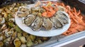 Fresh french Gillardeau oysters molluscs shucked on ice and other shells and shrimps ready to eat close up