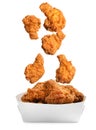 Fresh fried chicken falling into container on white background