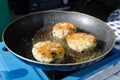 Fresh fried fish cakes pan frying in the sunlight