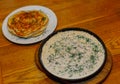 Fresh fried pancakes on a plate and gravy in a pan with sour cream herbs and mushrooms. tasty food