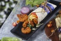 Fresh fried prawns roll with fresh tomatos, salad, cheese and onions isolated on bright blue background. Side view.cope space Royalty Free Stock Photo