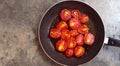 Fresh fried tomatoes. Fried red tomatoes in a pan as a background. Selective focus