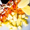 Fresh and frozen chopped vegetables,  Chopped carrots, potatoes, onions and red bell pepper on white cutting board Royalty Free Stock Photo