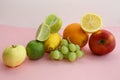 Fresh fruit apple, lime, avocado, lemon, orange, grapes on a light pink background Royalty Free Stock Photo