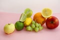 Fresh fruit apple, lime, avocado, lemon, orange, grapes on a light pink background Royalty Free Stock Photo