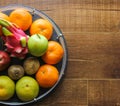 Fresh fruit basket containing dragon fruit, apples, kiwi, orange, pears on a wooden background. Royalty Free Stock Photo