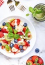 Fresh fruit and berry salad with cottage cheese, strawberries, blueberries, kiwis, oranges and mint leaves with honey dressing, Royalty Free Stock Photo