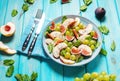 Fresh fruit and berry salad with grapes, fig and peach on blue wooden background Royalty Free Stock Photo