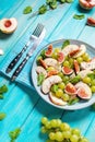 Fresh fruit and berry salad with grapes, fig and peach on blue wooden background Royalty Free Stock Photo