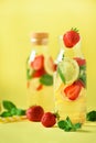 Fresh fruit flavored water with strawberry, lemon, mint on yellow background. Summer drink concept. Copy space. Infused Royalty Free Stock Photo